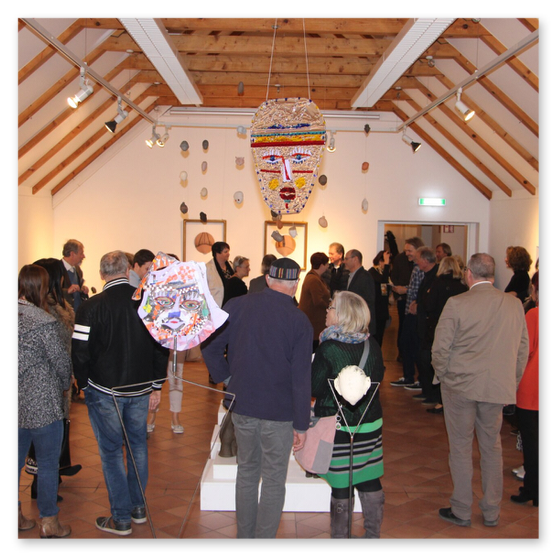 Ausstellung im Kunsthaus in Weiz. Skulpturen, Masken und Köpfe aus Keramik und Masken aus Glas. Gäste bei der Vernisage.