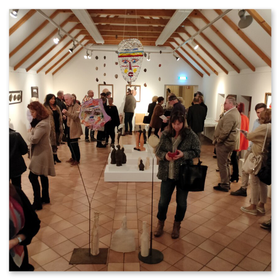 Ausstellung im Kunsthaus in Weiz. Skulpturen, Masken und Köpfe aus Keramik und Masken aus Glas. Gäste bei der Vernisage.