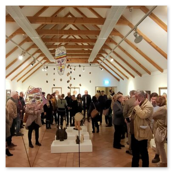 Ausstellung im Kunsthaus in Weiz. Skulpturen, Masken und Köpfe aus Keramik und Masken aus Glas. Gäste bei der Vernisage.