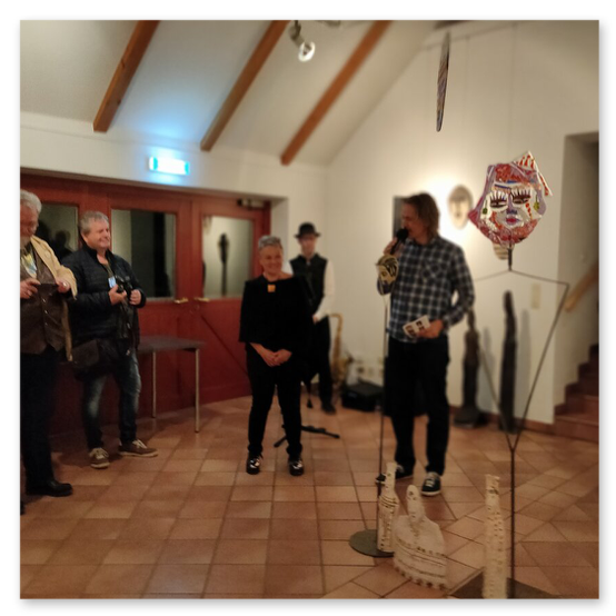 Ausstellung im Kunsthaus in Weiz. Skulpturen, Masken und Köpfe aus Keramik und Masken aus Glas. Gäste bei der Vernisage.