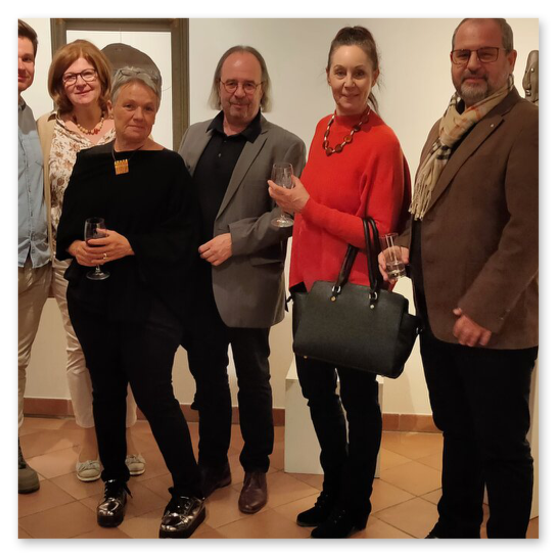 Ausstellung im Kunsthaus in Weiz. Skulpturen, Masken und Köpfe aus Keramik und Masken aus Glas. Gäste bei der Vernisage.
